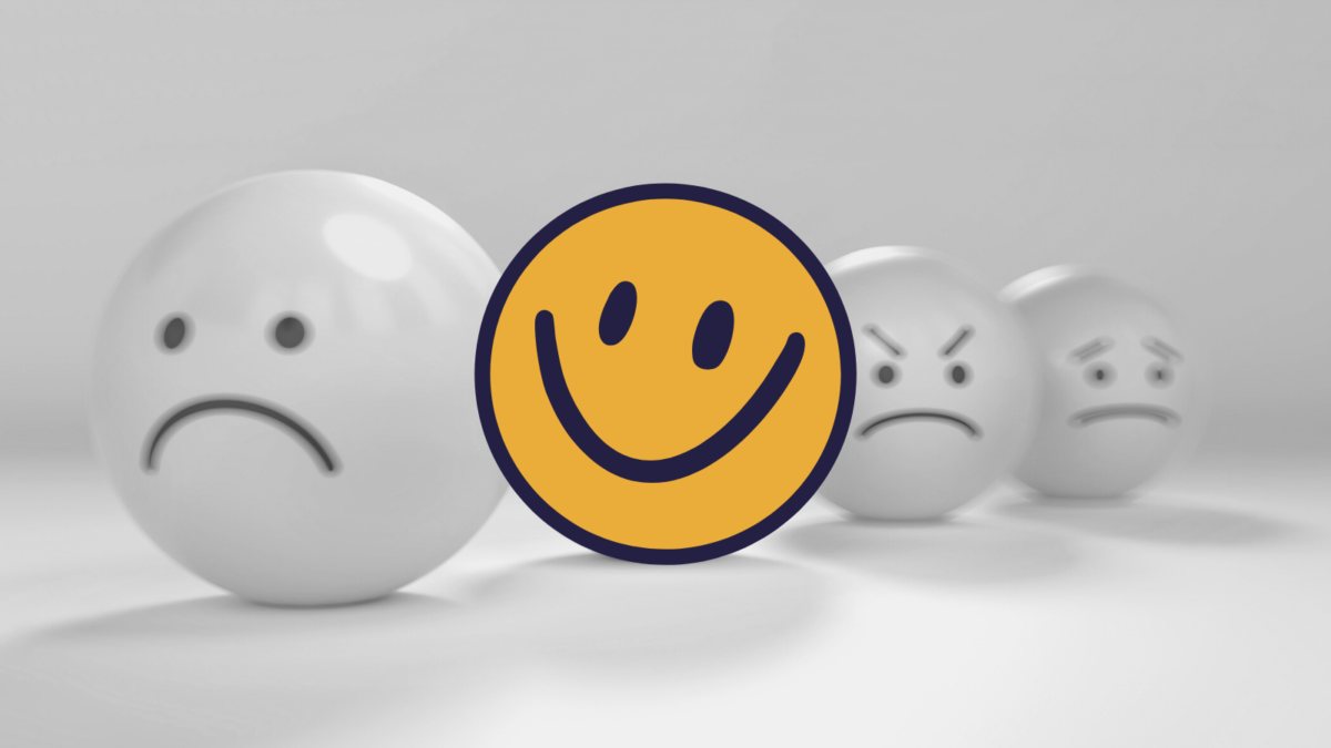 A yellow smiling face next to frowning faces in black and white.