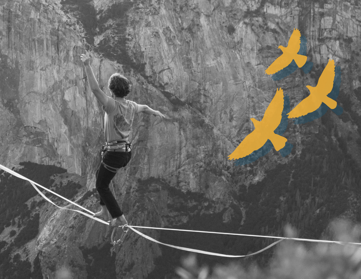 Man is walking across a tightrope over a canyon. Yellow outline of three birds fly above him.
