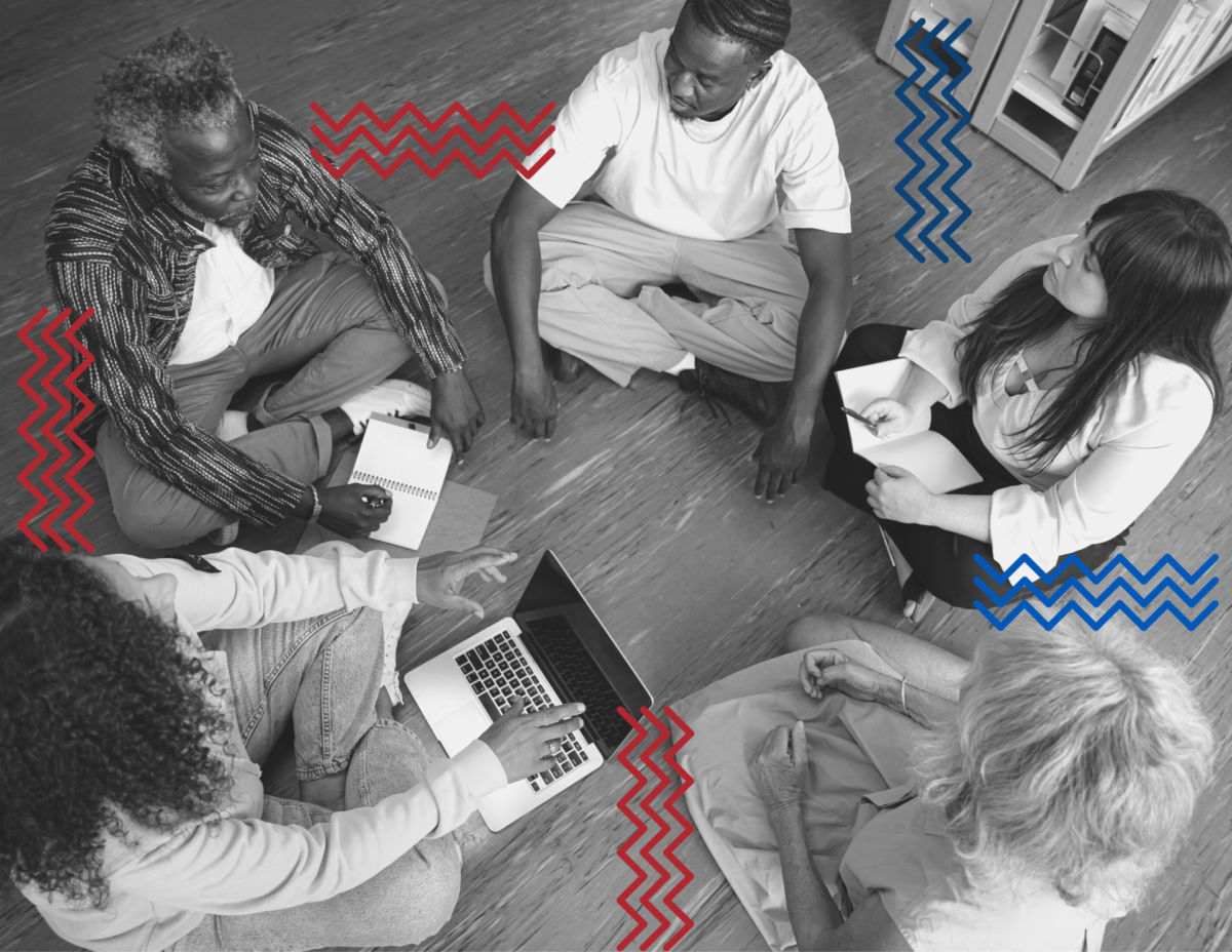 group of people sitting on the floor in a circle. a woman has her laptop open